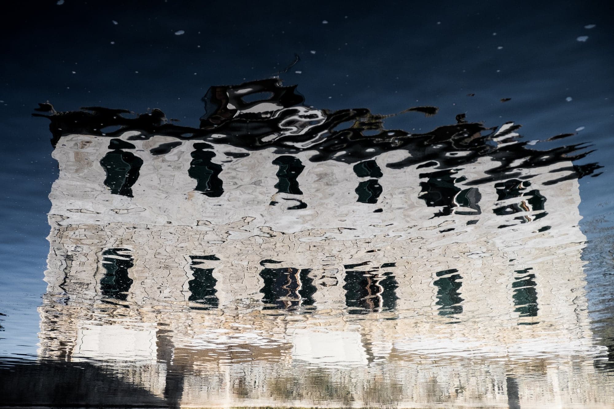 A ruined building reflected in water
