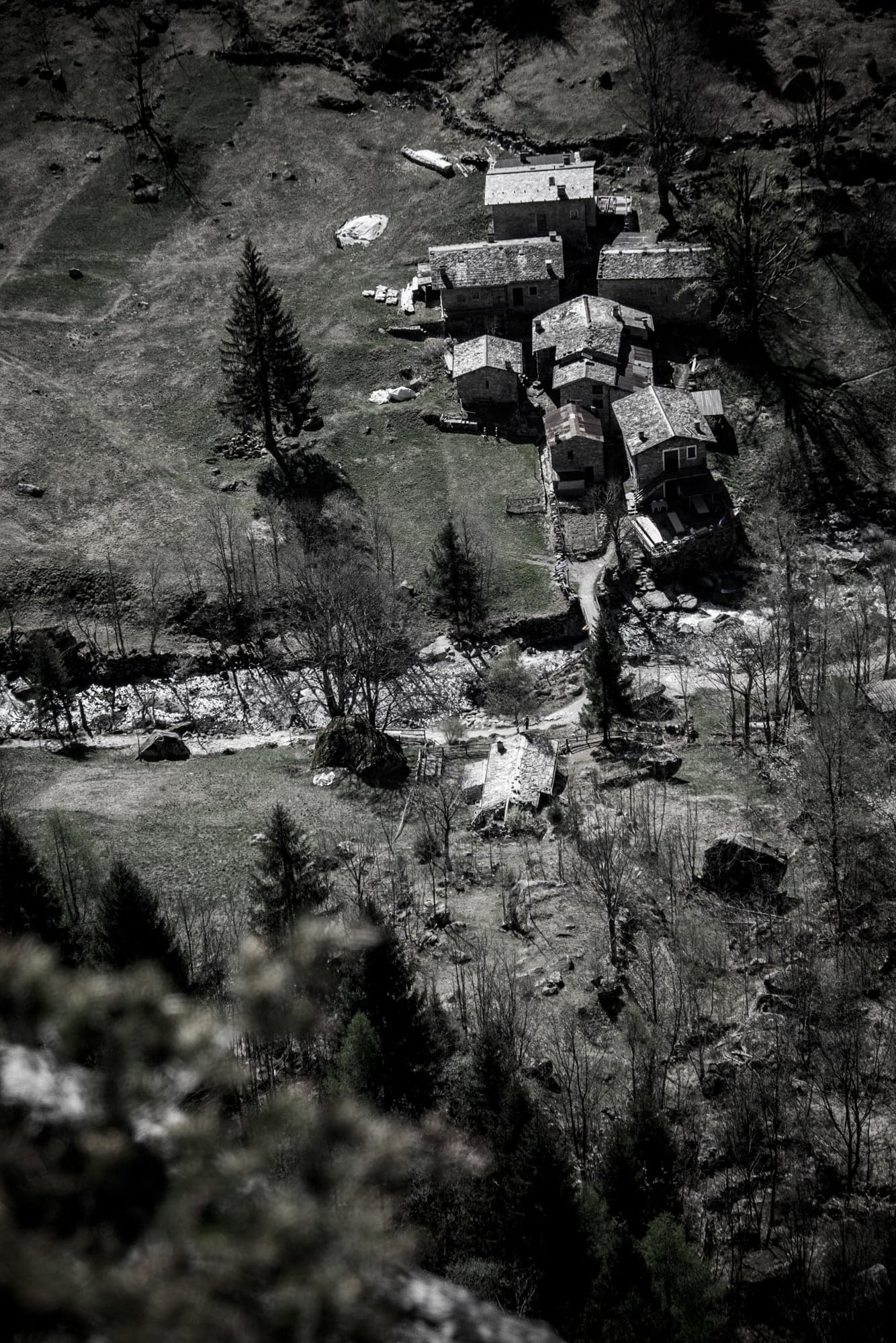 Shanties scattered on a hillside, in black and white