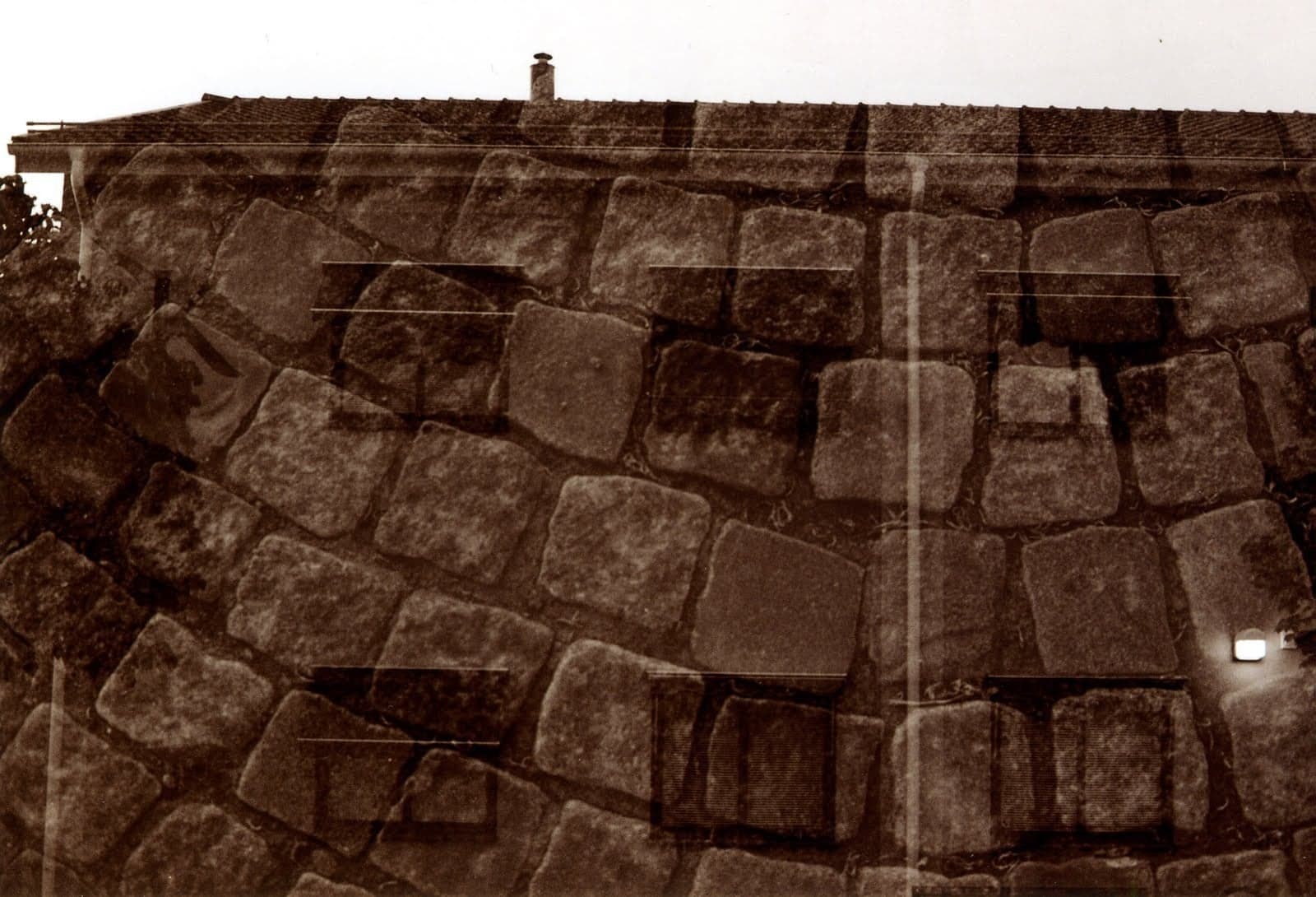 Eine Pflastersteinmauer, die in eine Dachkante kippt