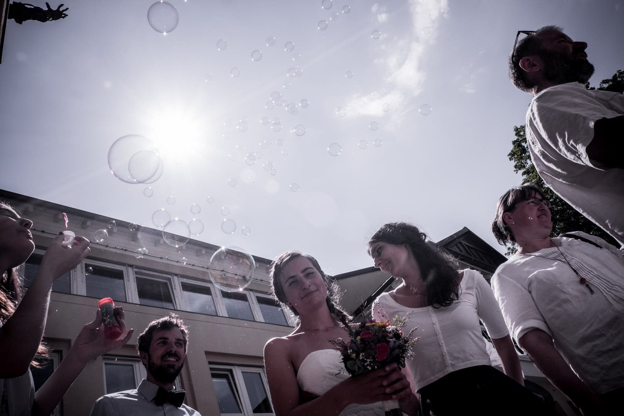 A wedding crowd under a blazing sun