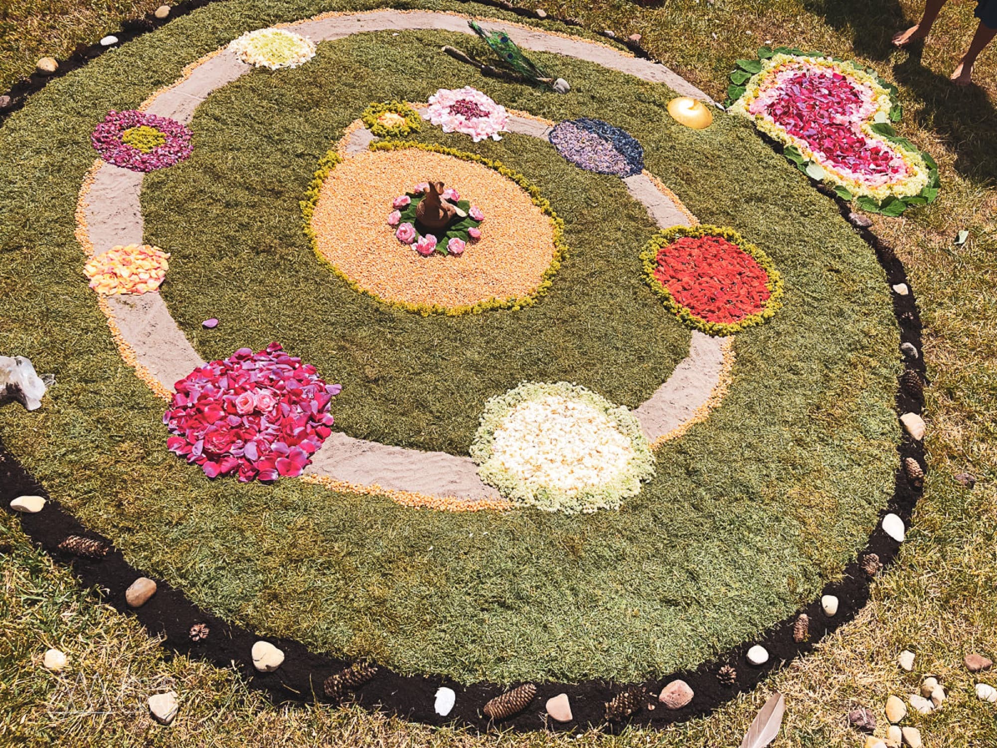 A flower mandala on the grass, from above