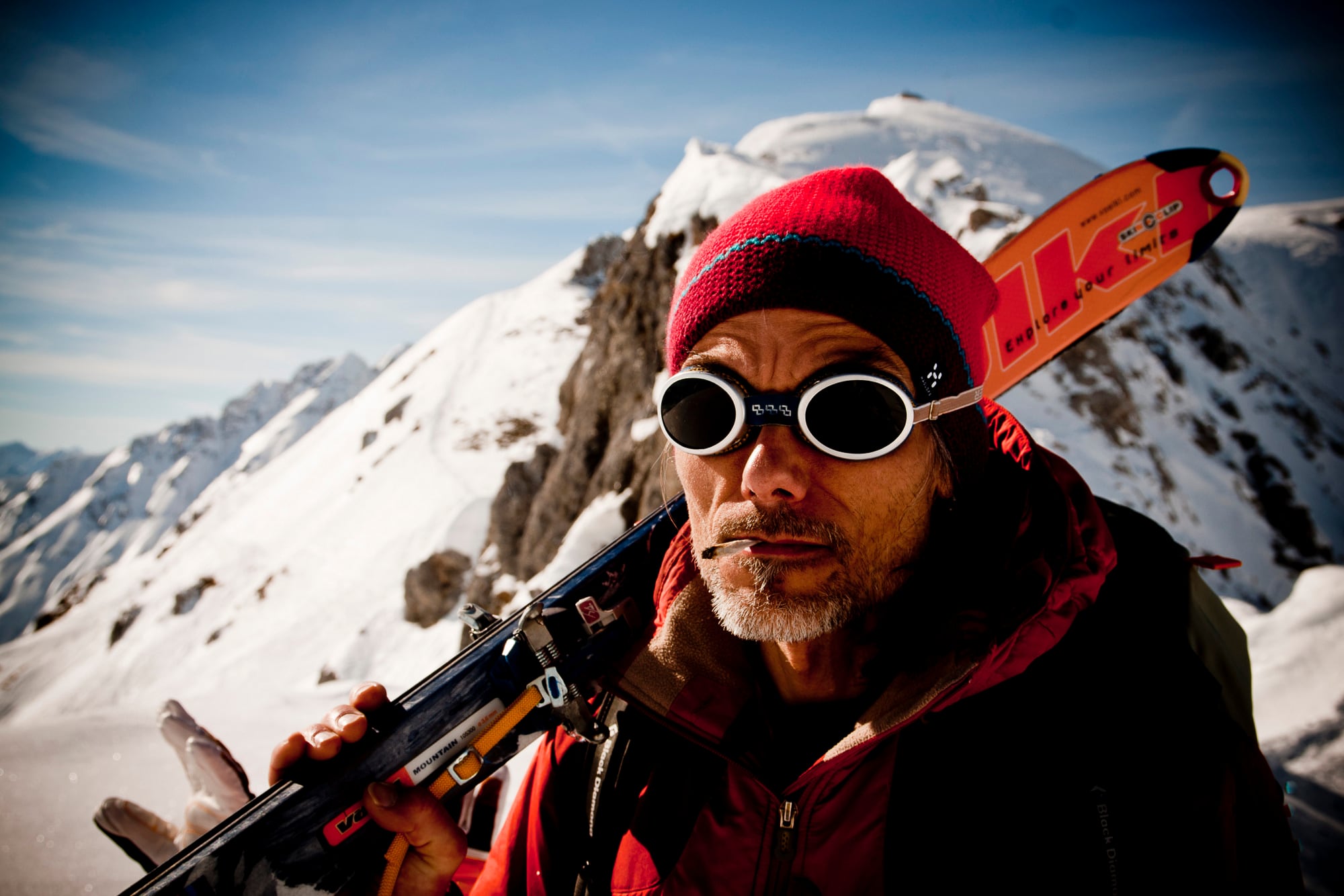 Ein Skifahrer mit Brille und Ski auf verschneitem Grat