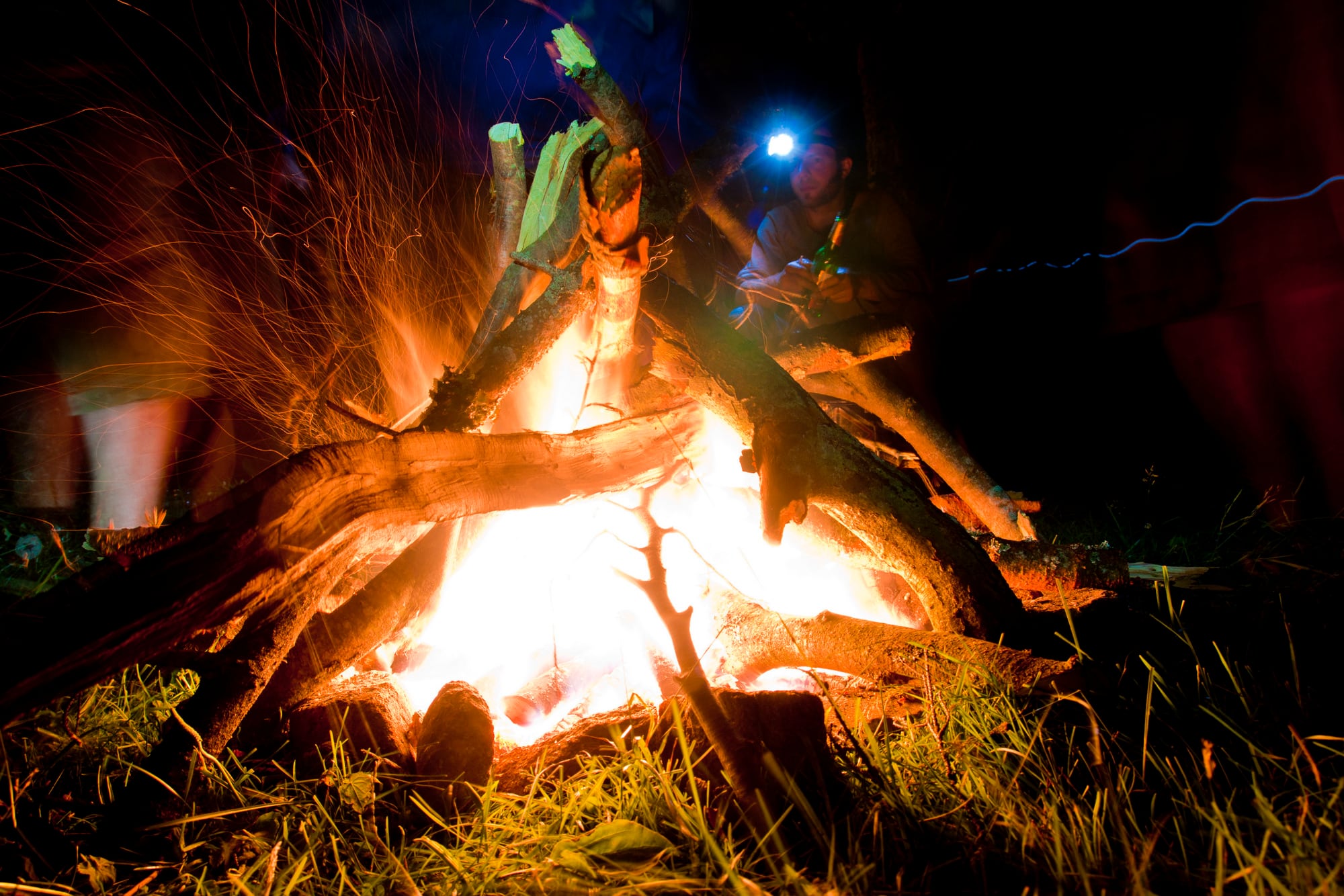 Eine Gestalt am nächtlichen Lagerfeuer