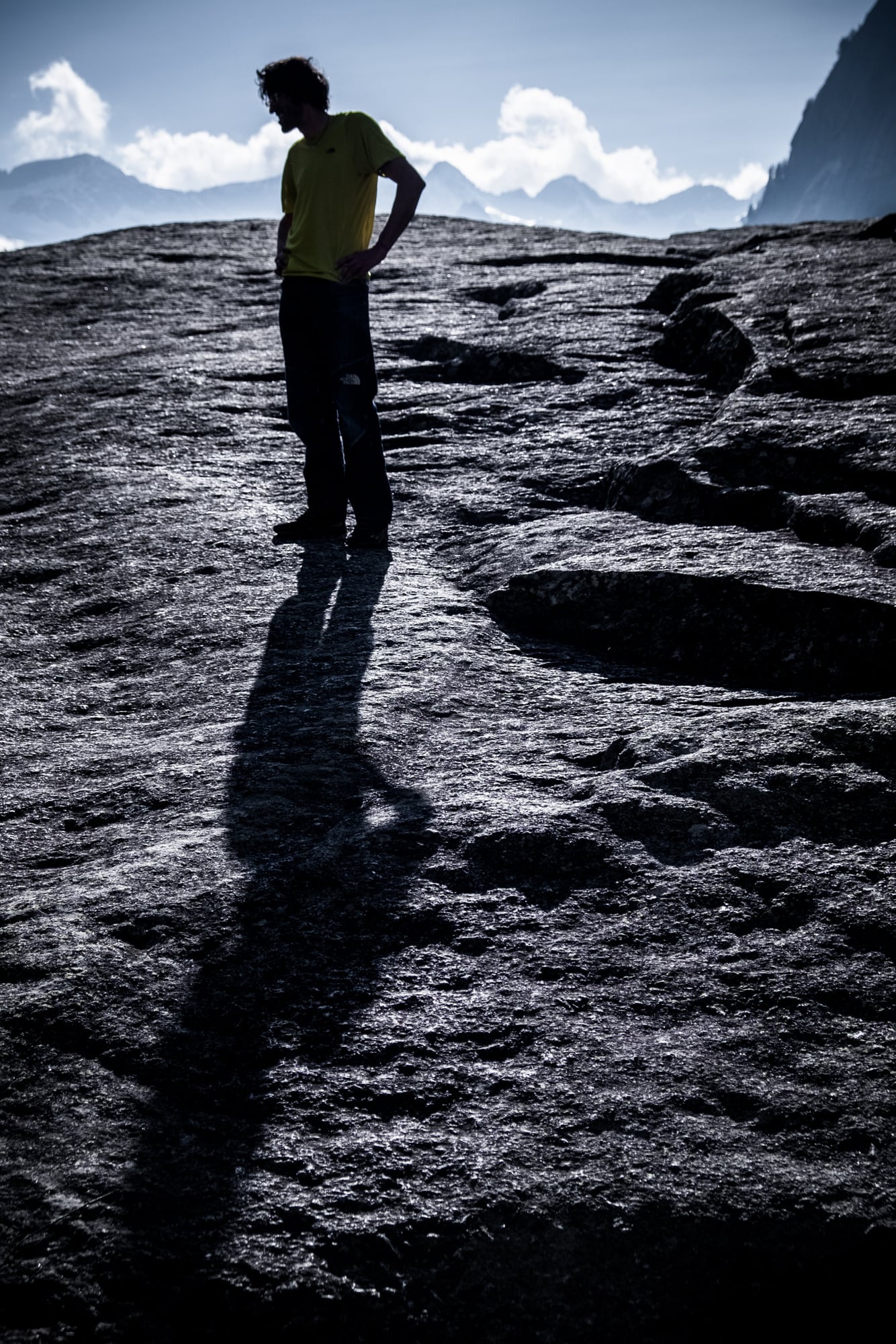 Eine Gestalt als Silhouette auf einem kahlen Felsgrat