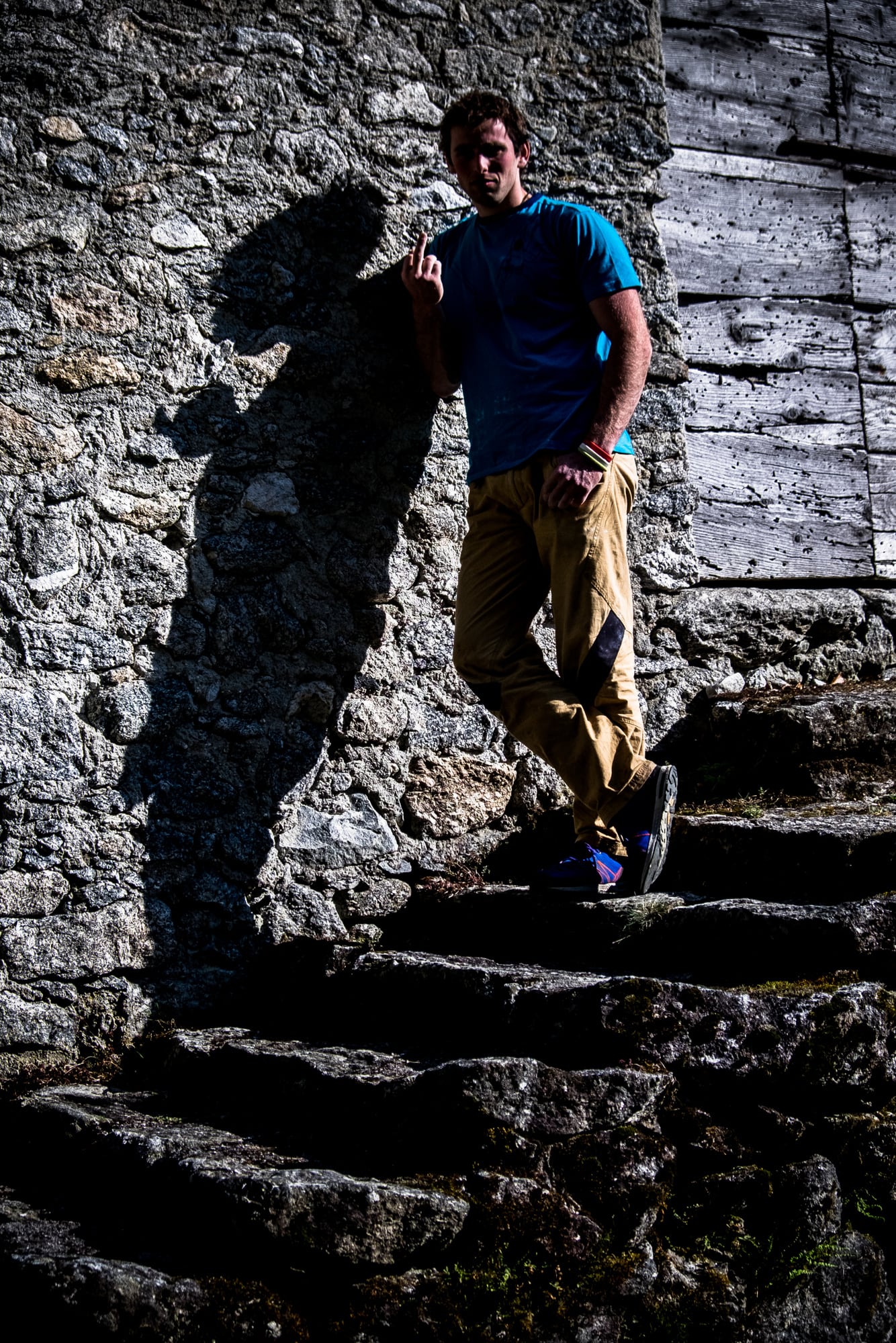 Ein Mann lehnt an einer Steintreppe, ein langer Schatten daneben