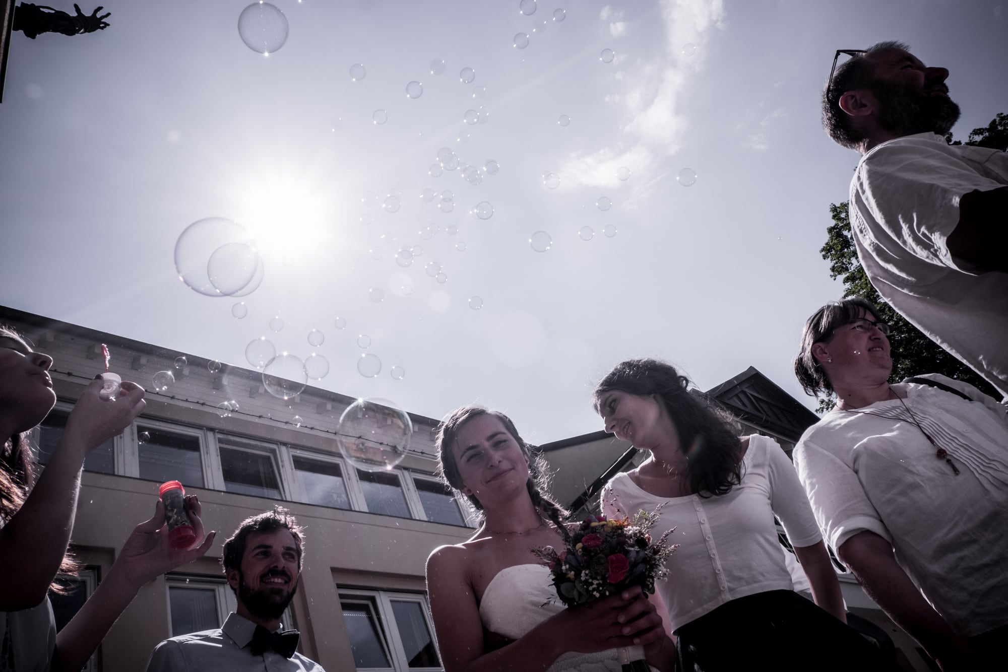 Eine Hochzeitsgesellschaft unter greller Sonne