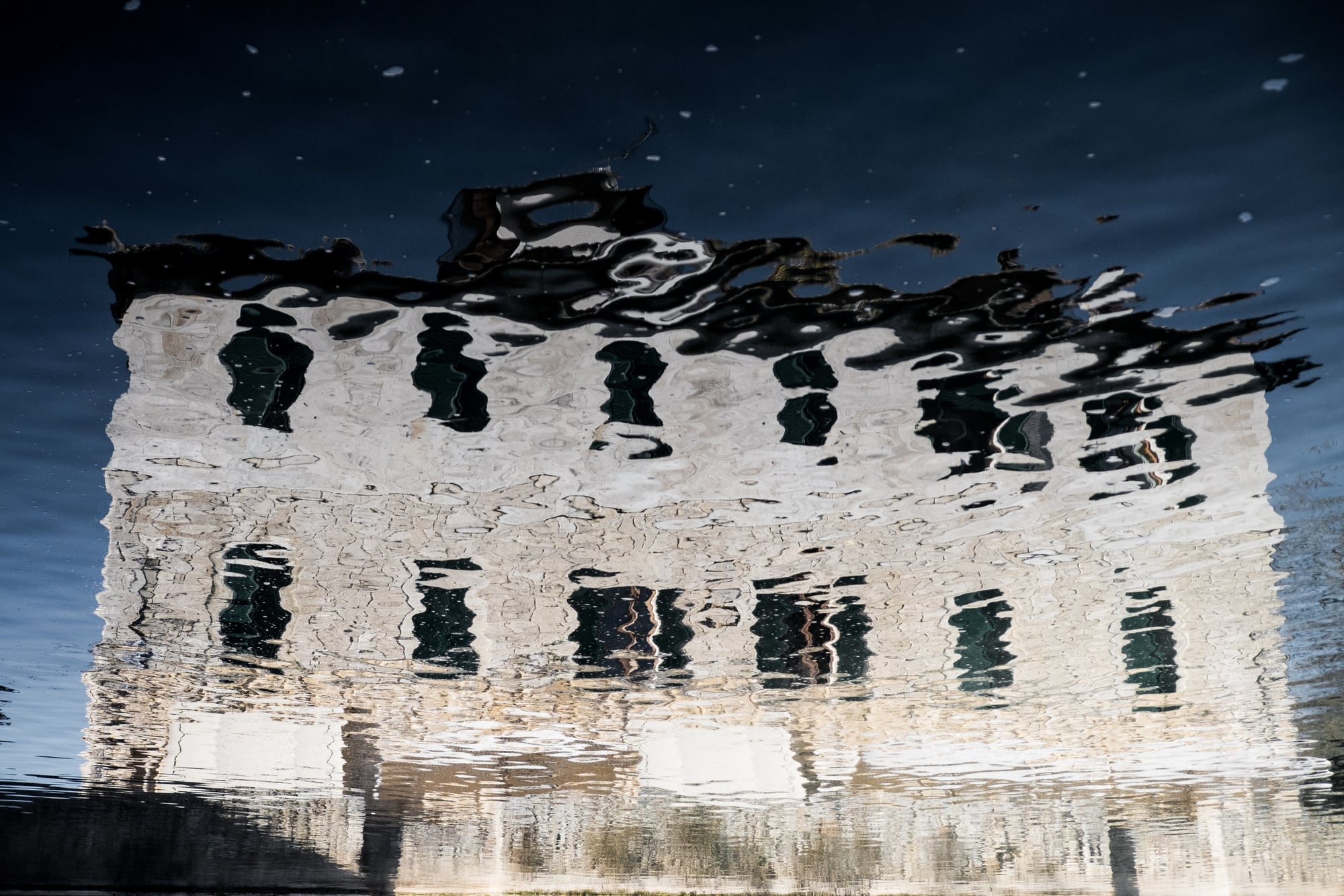 Ein zerfallenes Gebäude, im Wasser gespiegelt
