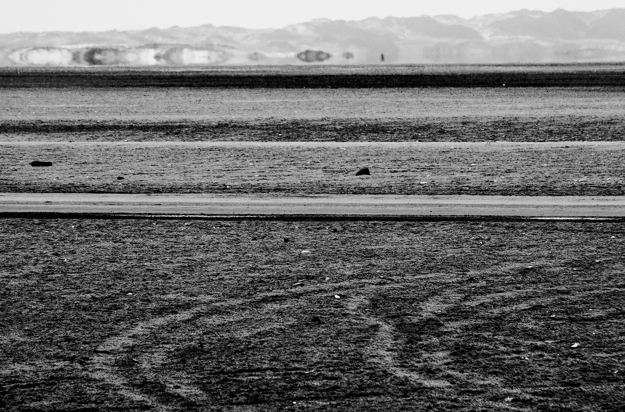 In Strandsand geharkte Muster, in Schwarz-Weiß