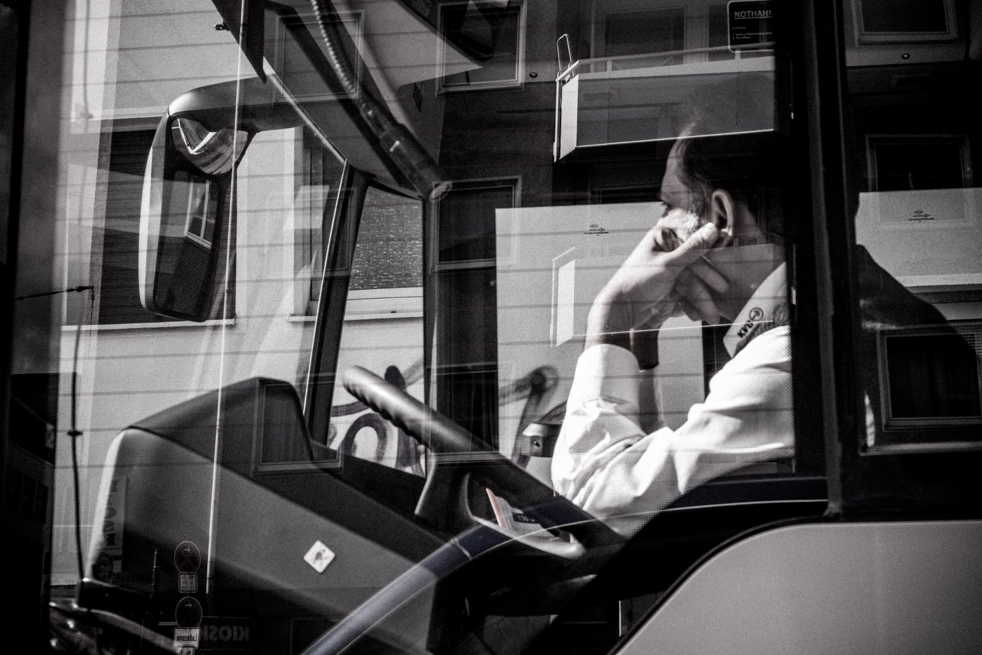 Ein Busfahrer am Telefon, in Schwarz-Weiß